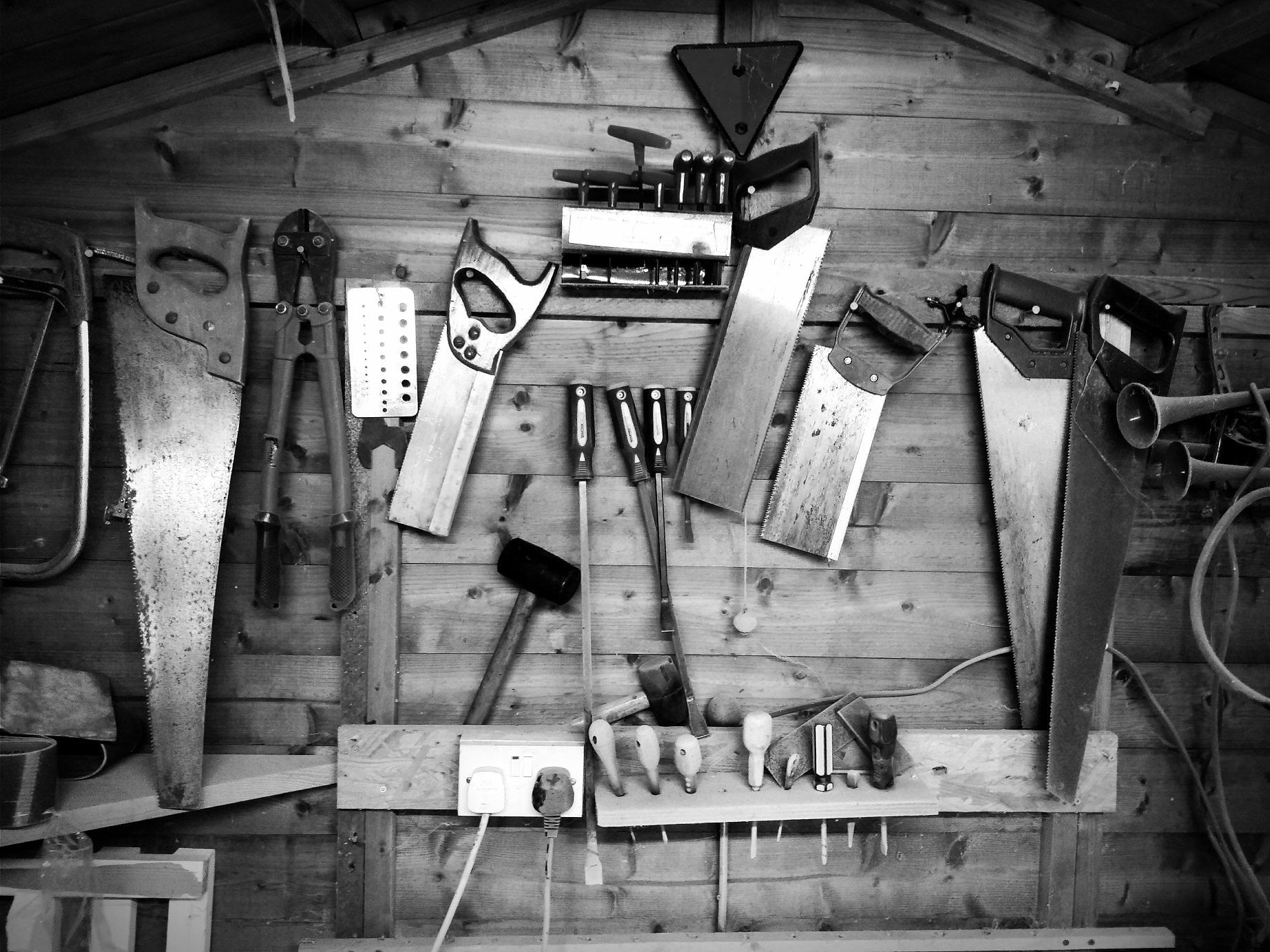 Saws and hand tools on garage wall