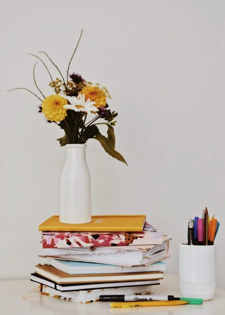 flowers, vase, and books, symbols of sustainability education