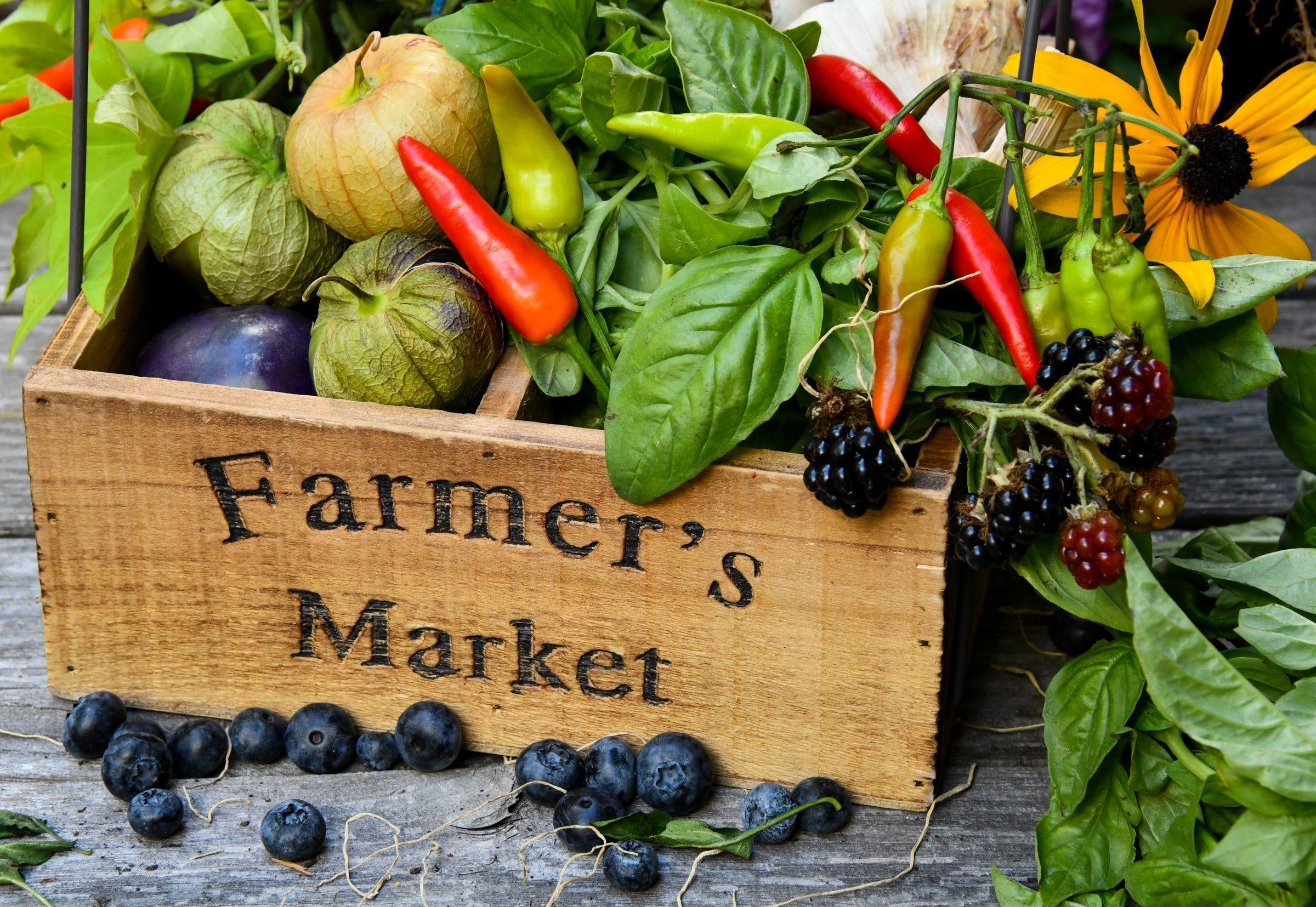 Wooden box labelled 'Farmer's Market' full of vegetables