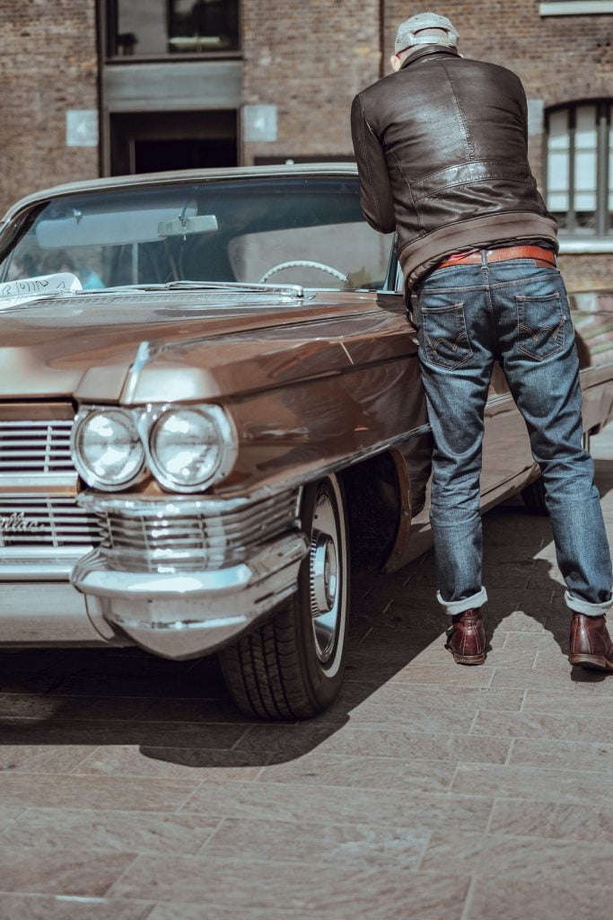 man in vintage jeans by car