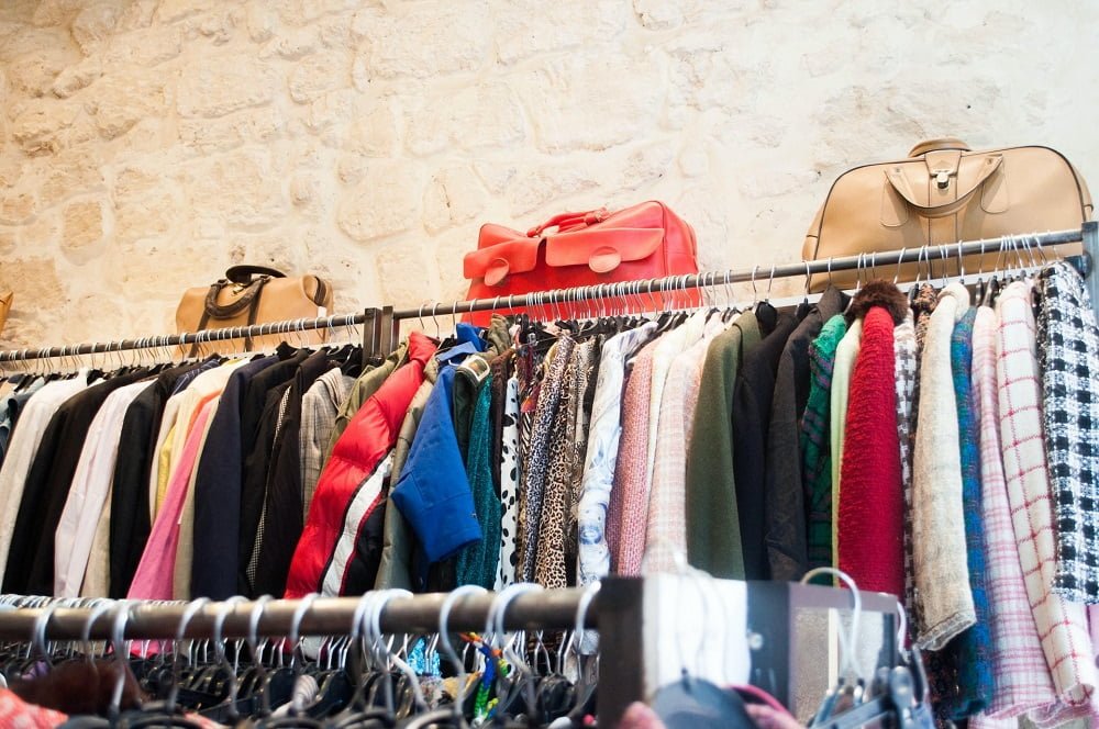 How to Recycle Old Clothes: vintage clothes lined up on a rack in a thrift store