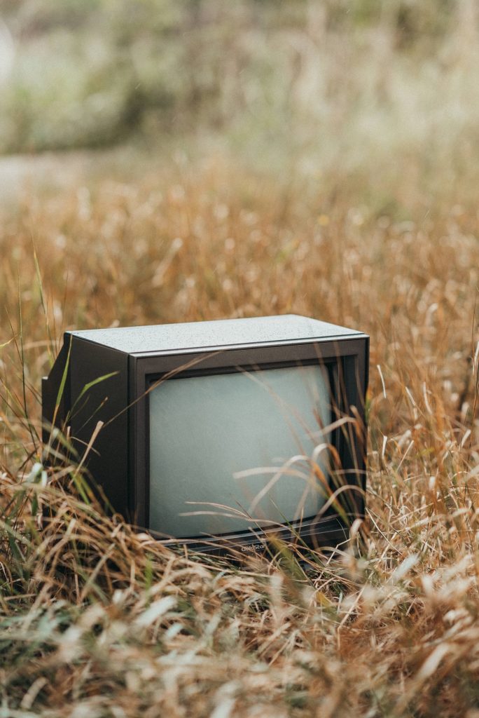 E-waste Problem: A vintage tv sitting in a grassy field