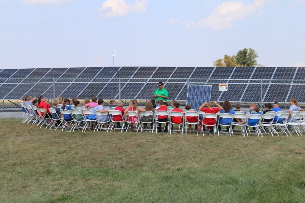 crowd at solar panels discussing technology