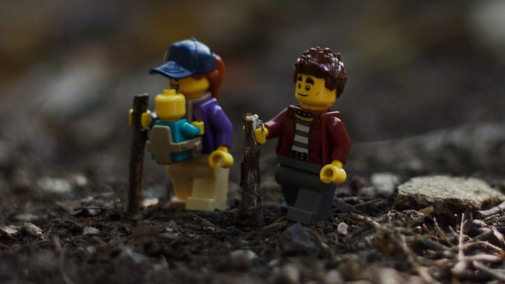 Sustainable Toys: LEGO figurines walking through the forest