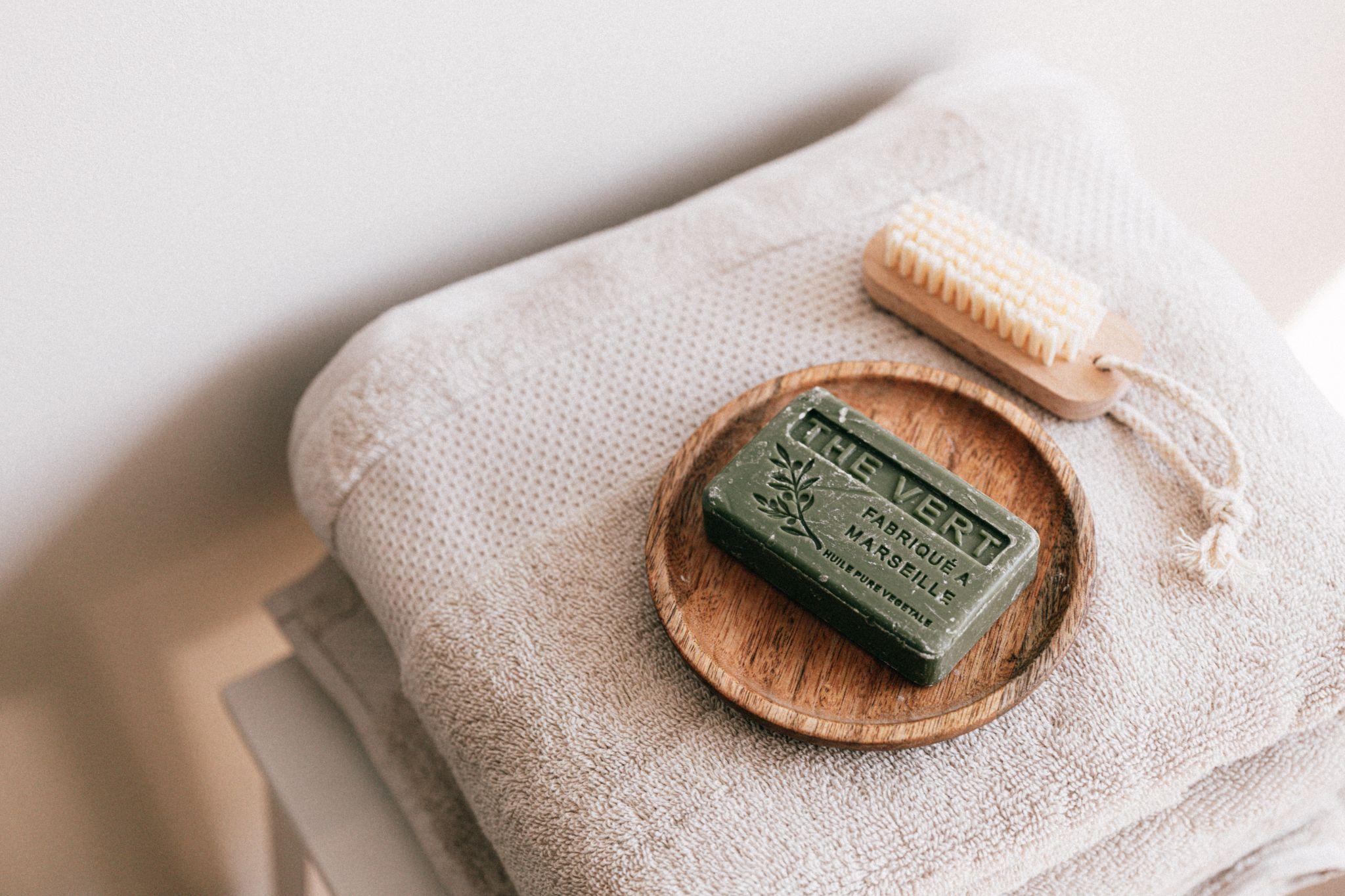 Cruelty-Free Skincare: Handmade soap and a wooden-handled brush on a folded towel