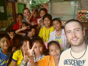 How To Make Your TEFL Teaching More Eco-Conscious: Smiling school children and teacher