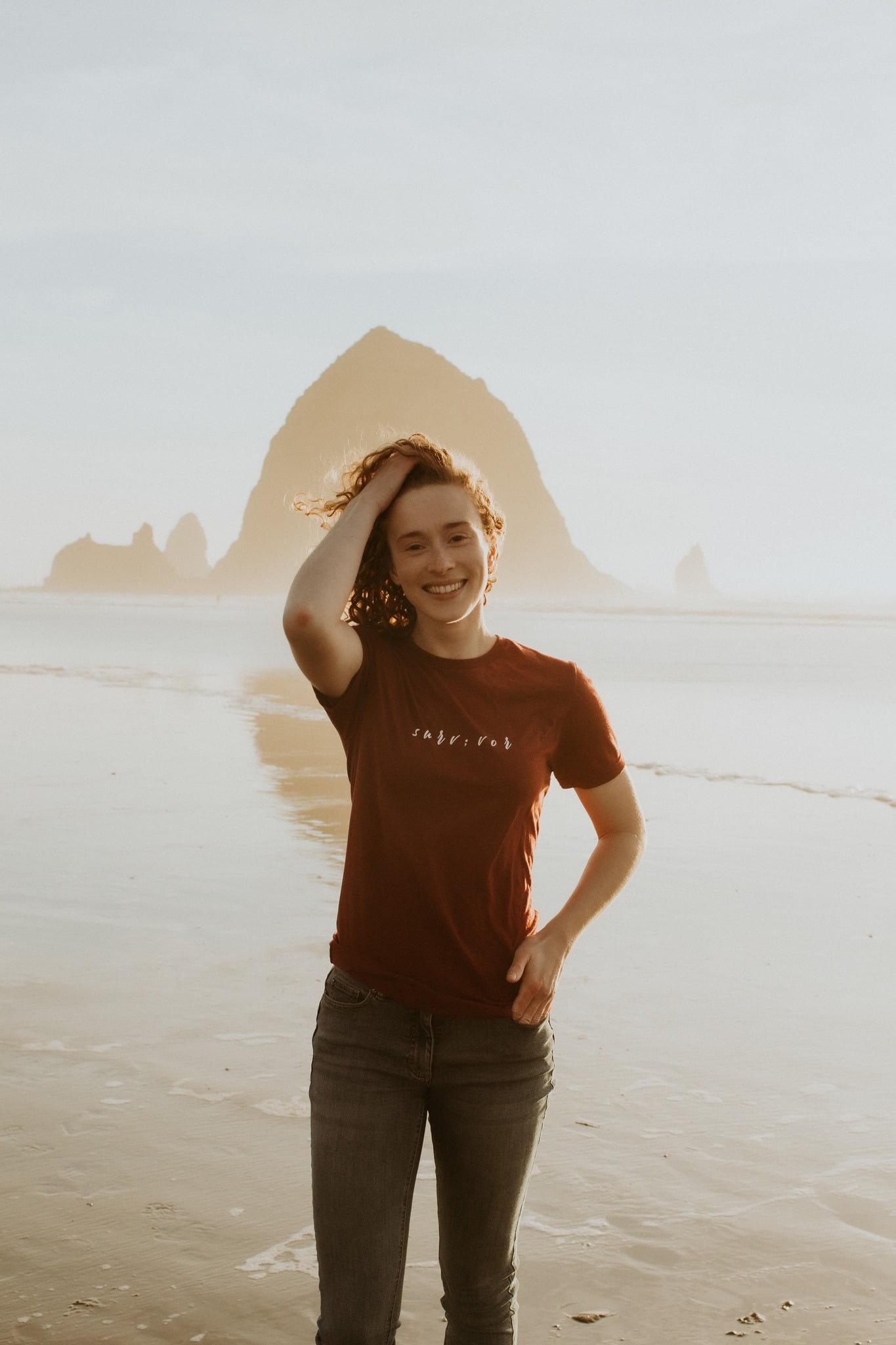 Jessi Beyer, founder of Mental Health Apparel Brand - How to Heal Co., smiling at the beach