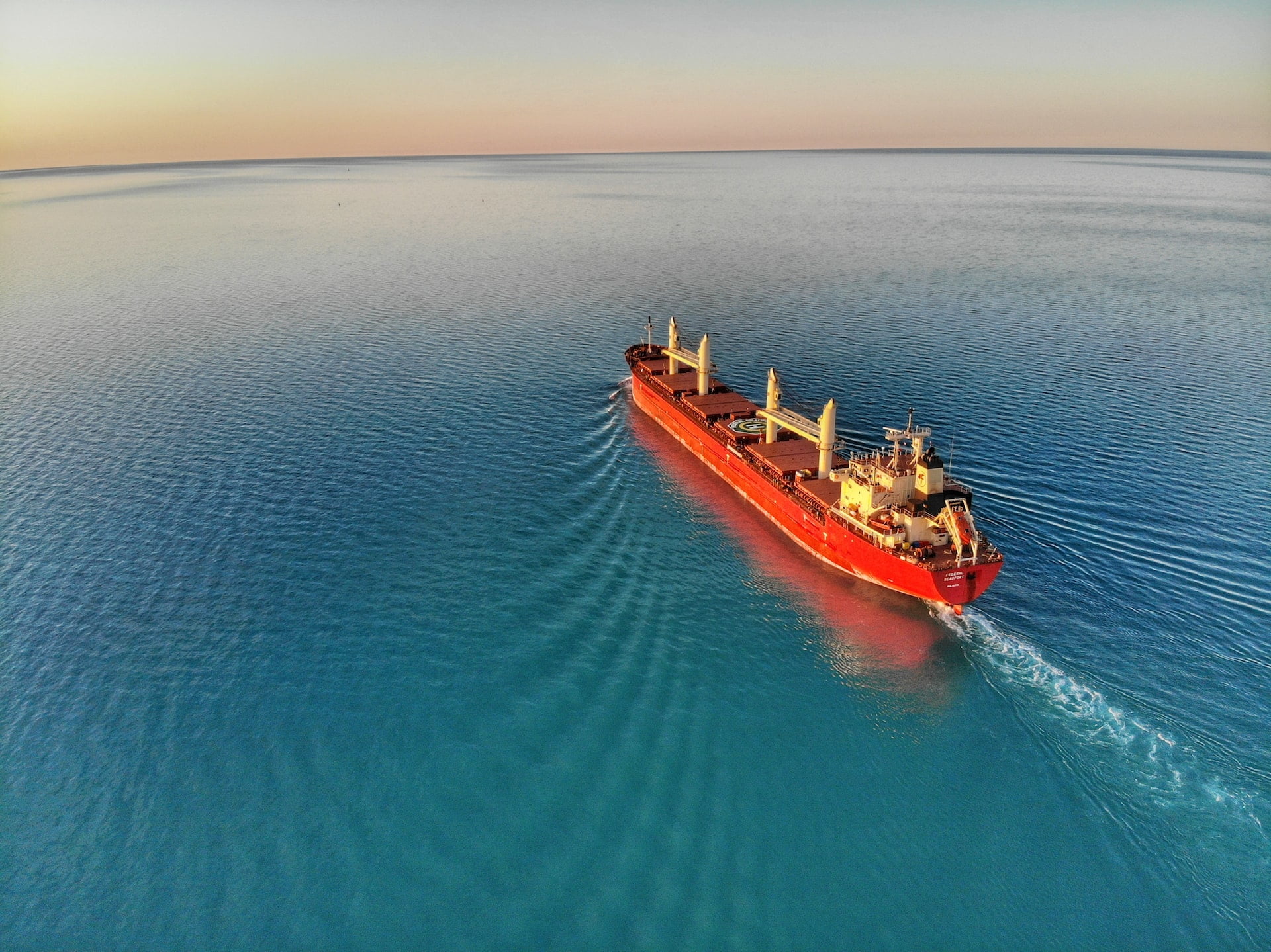 Can the Shipping Industry Achieve Carbon Zero? A large freight vessel out at sea at dawn
