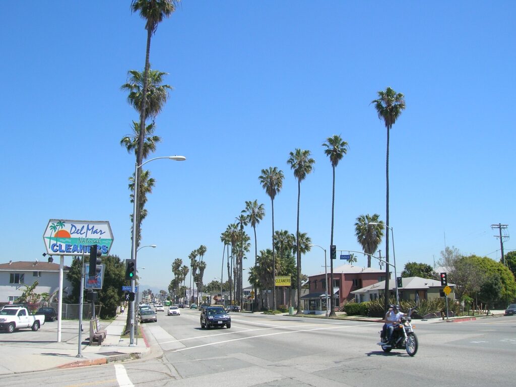 Traffic passing through the suburban streets of Los Angeles under a blue sky