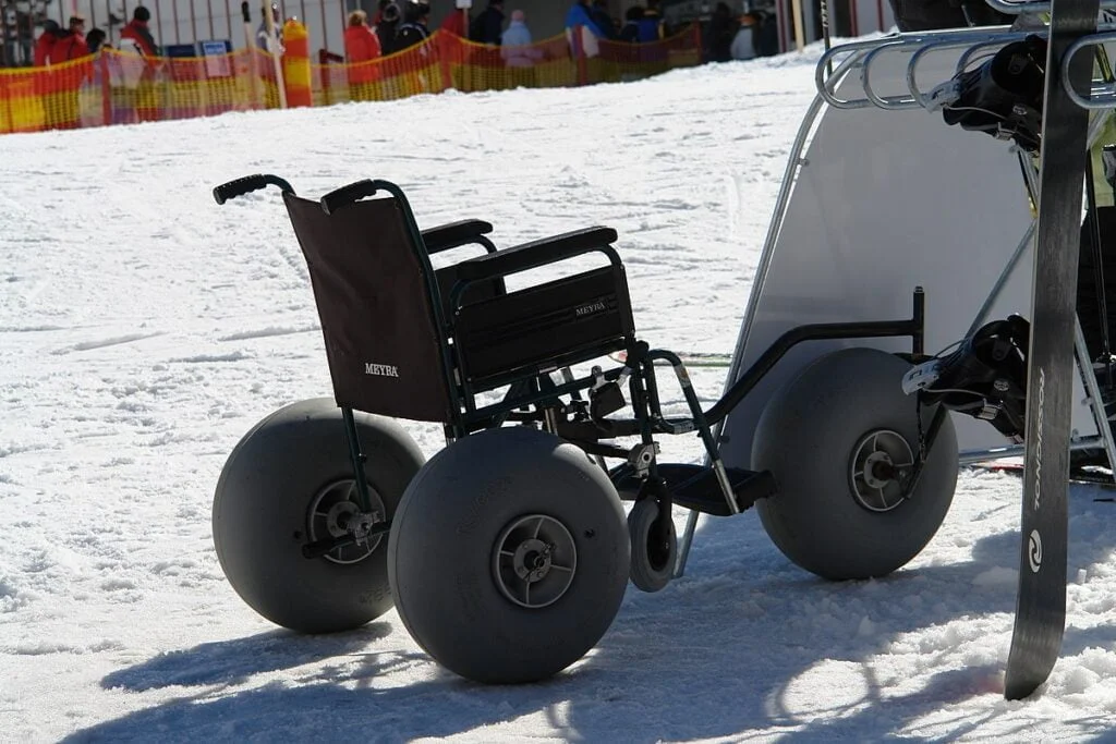Accessibility in Tourism: Snow wheelchair with extra-wide inflated tires for travel on top of snow