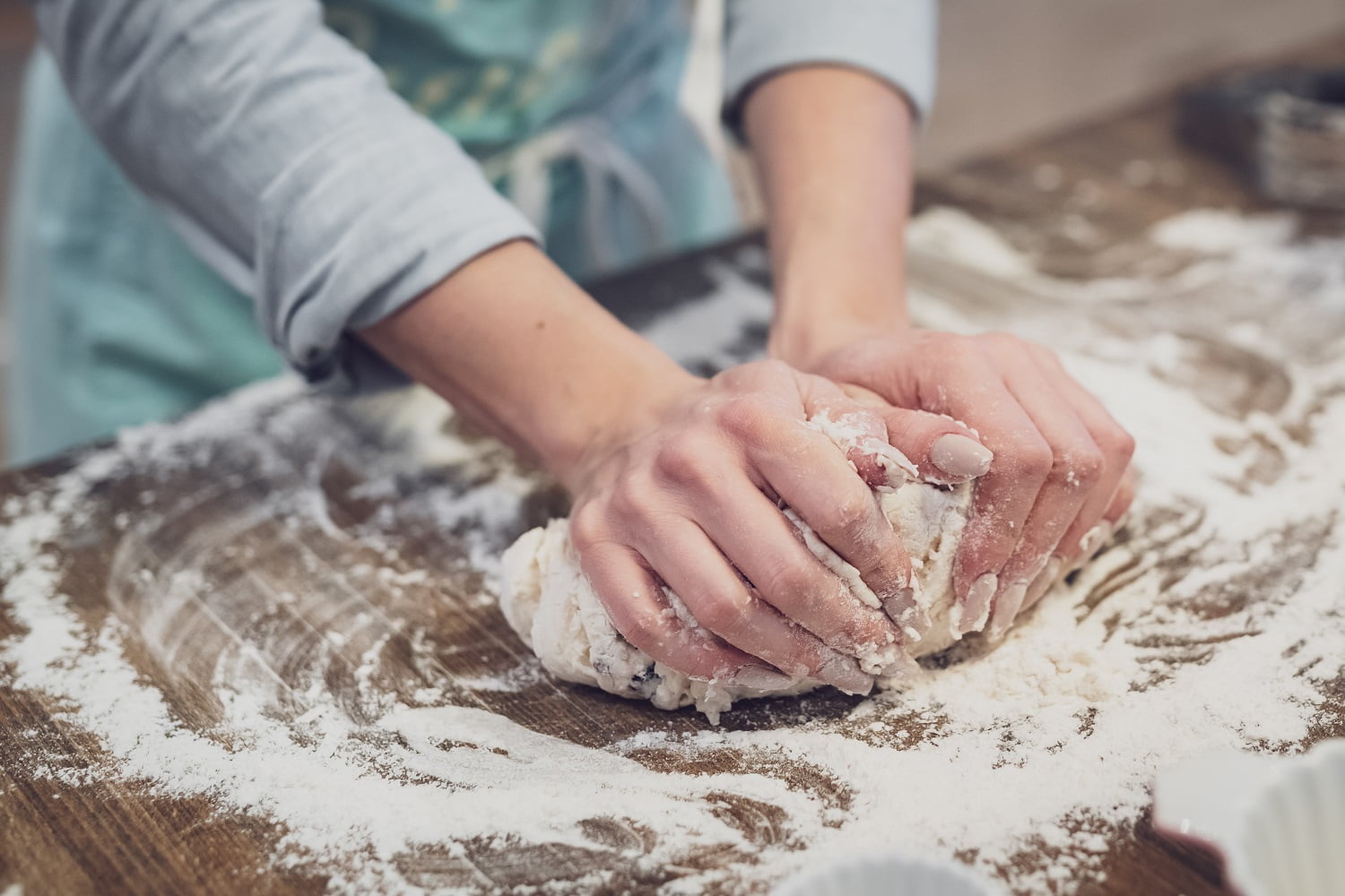 Eco-Friendly Kitchen: hands kneading dough in flour on a board