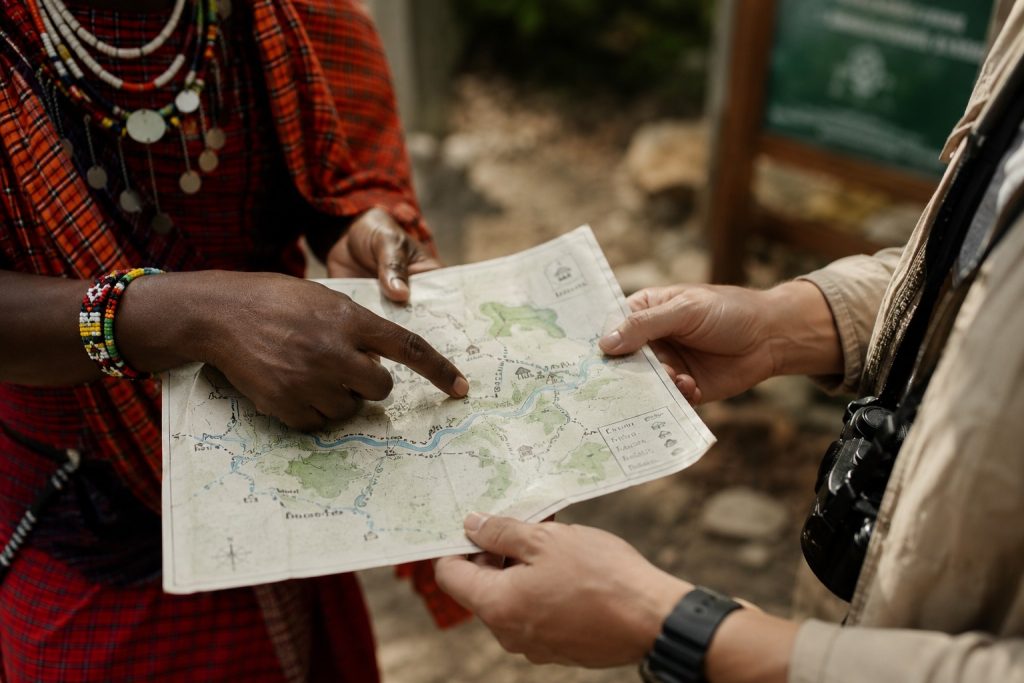 A local guide and traveller look over a paper map together during a community-led travel experience.